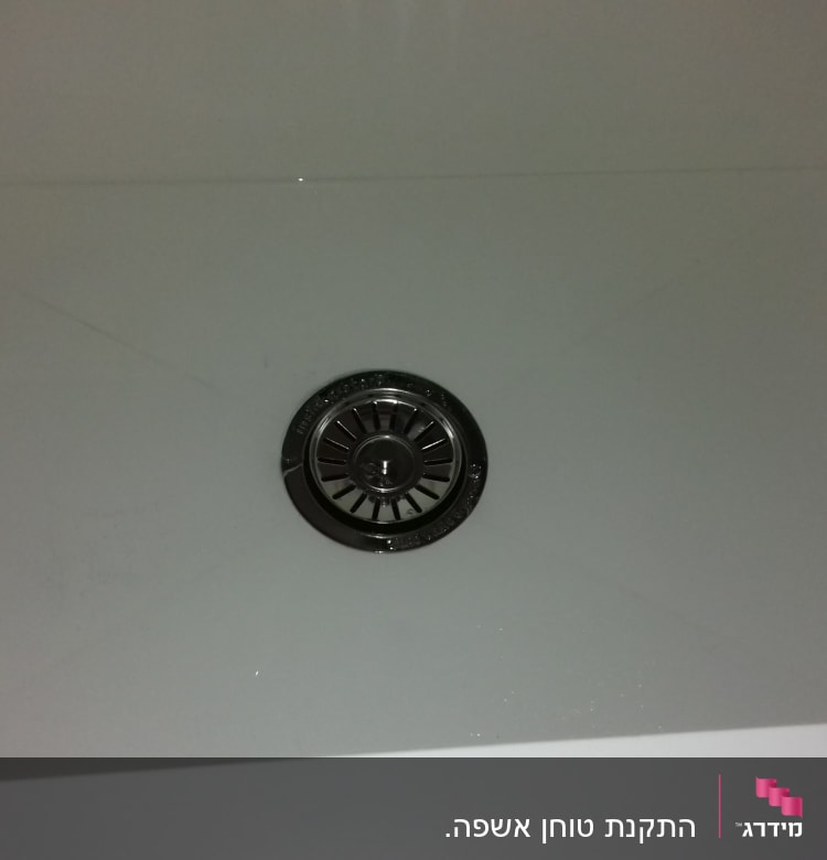 ניקוז מתכת בכיור לבן